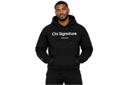 “Black male model wearing a black Chi Signature Chicago hoodie with white chest lettering, hands in the front pouch pocket.”