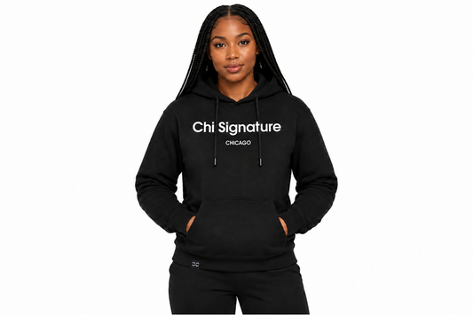 A woman modeling a black pullover hoodie with 'Chi Signature CHICAGO' printed in white across the chest, set against a plain white background.