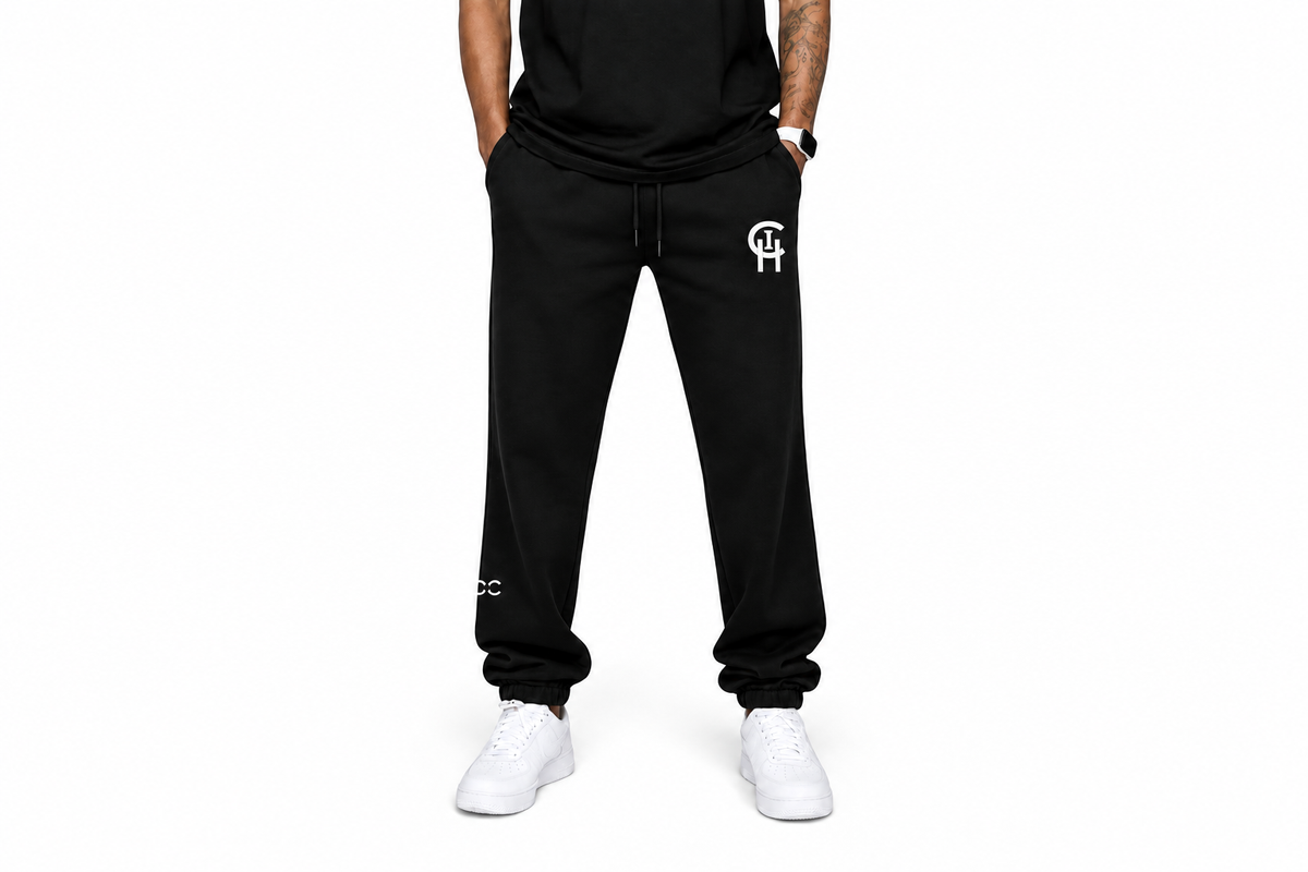 A person wearing black sweatpants with a white 'CHI' logo on the left thigh and white sneakers, shown from the waist down against a plain white background.
