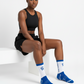 Black Woman wearing black athletic wear and royal blue socks with a chi logo on a white background