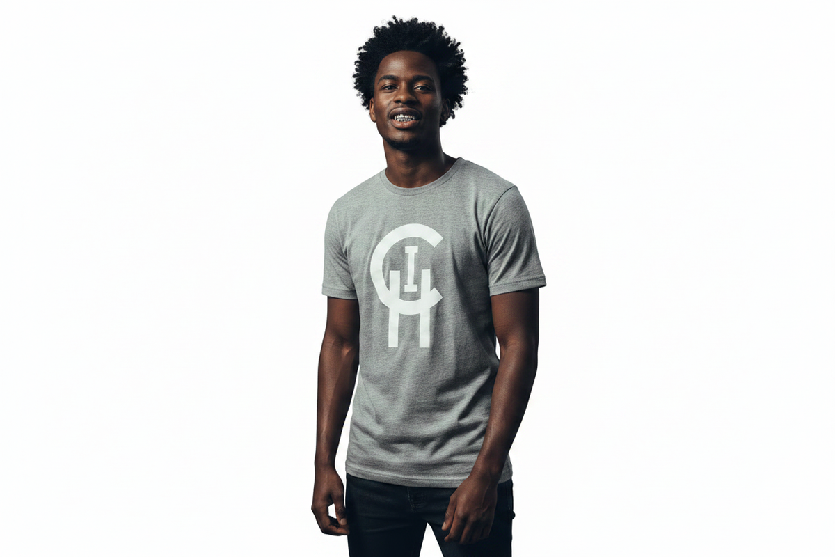 A man wearing a heather gray crewneck t-shirt with a large white stylized 'Chi logo on the front, standing against a solid white background.